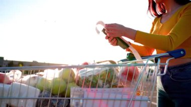 Endişeli kadın marketten alışveriş yaptıktan sonra gazete fişini kontrol ediyor. Covid-19 küresel ekonomi finansal kriz konsepti, para tasarrufu. Yiyecek ve market alışverişi. Yüksek kalite 4k görüntü