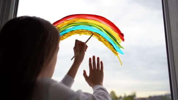 Een Kind Tekent Een Regenboog Het Glas Van Een Balkon — Stockvideo