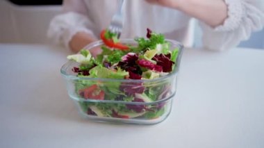 Yeşil salatayı kaseye karıştıran kadının yakın çekimi. Aile yemeği için sağlıklı yemek pişirmek. Yüksek kalite 4k görüntü