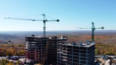 Yüksek modern konut binasının ve yapım aşamasındaki vinç kulesinin havadan görüntüsü. Yüksek kalite 4k görüntü