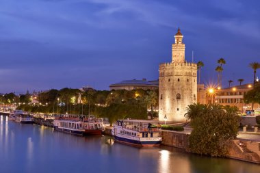 Seville, İspanya, 2 Şubat 2021 Torre del Oro ve San Telmo köprüsünden öğle vakti tuz rıhtımının manzarası.