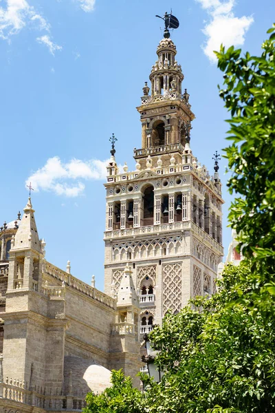 Giralda Tower przeciwko jasnemu niebieskiemu niebu z białymi chmurami. — Zdjęcie stockowe