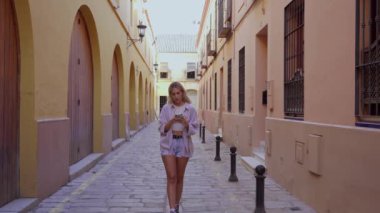 Sokakta yürüyen bir kız cep telefonundan iyi haberler alıyor. Zaferi kutlayan yüce kız başarının tadını çıkarıyor..