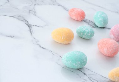 Mermer bir masanın üzerinde çok renkli Paskalya yumurtalarının yerleşimi. Yumuşak odaklanma. Yakın plan. Boşluğu kopyala.