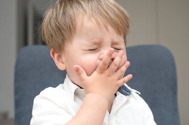 - İnsanlar. Yavrum. Beyaz gömlekli, yakışıklı, beyaz, duygusal küçük çocuk gözlerini bozmuş. Yakın plan. yumuşak odak