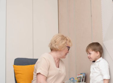 - İnsanlar. Kafkasyalı aile büyükannesi ve torunu ev içinde oynuyorlar. Birbirinizin gözlerine bakın. Aile kavramı