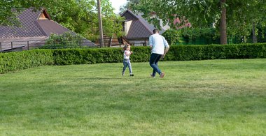 - İnsanlar. Bir aile. Kafkasyalı baba ve küçük güzel kız yazın parkta oynarken eğleniyorlar. Yumuşak odaklanma. Kavram.