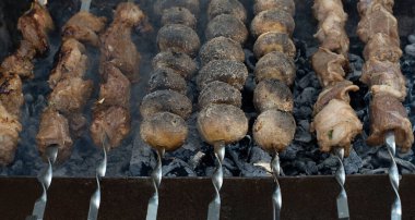Food. Potatoes and meat on a skewer are fried on the grill. Cooking food in nature on fire. Concept. Close-up. Soft focus.