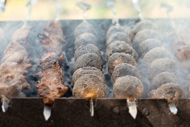 Food. Potatoes and meat on a skewer are fried on the grill. Cooking food in nature on fire. Concept. Close-up. Soft focus.