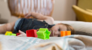 Mutlu ve neşeli 8 aylık bebek evde renkli tuğlalarla oynuyor.