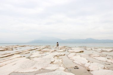 Issız bir kaya plajında yalnız kız