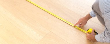 Mimar yeni ahşap zeminin ölçüsünü alıyor. Ev ve bakım kavramları