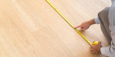 Mimar yeni ahşap zeminin ölçüsünü alıyor. Ev ve bakım kavramları