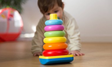 10 aylık tatlı bebek yerde oynuyor.