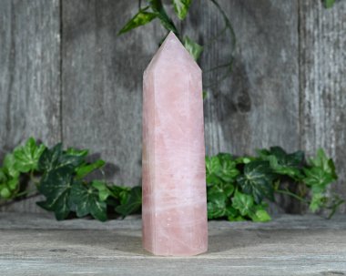 Ahşap arka planı olan Pembe Gül Kuvars kristal kulesi