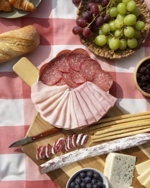 Ahşap masada salam ve peynir çeşitleri.