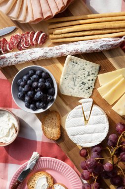Tahta masada çeşitli peynir ve şarap çeşitleri.