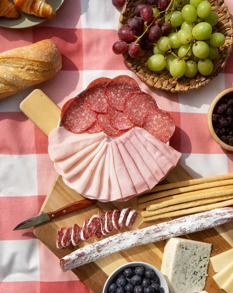 Ahşap masada salam ve peynir çeşitleri.