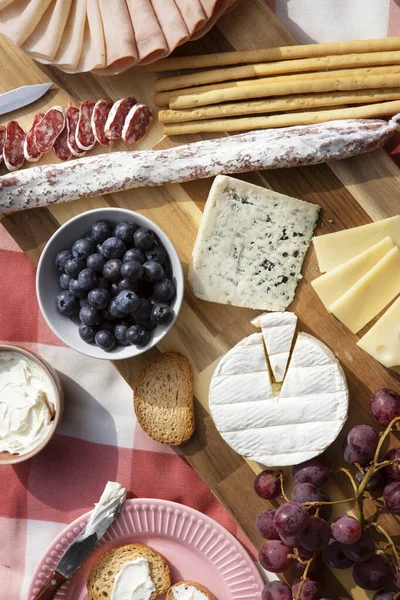 Tahta masada çeşitli peynir ve şarap çeşitleri.