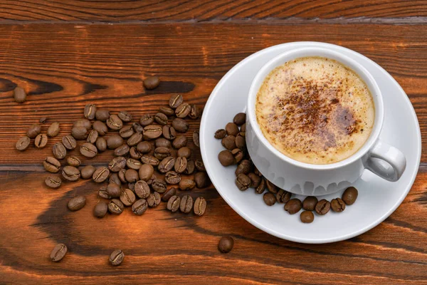 Cangkir Putih Dengan Cappuccino Dan Biji Kopi Dengan Latar Belakang — Stok Foto