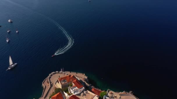 Плавучі яхти і моторний човен в літній сонячний день у морі біля міської стіни на острові Гідра в Греції. — стокове відео