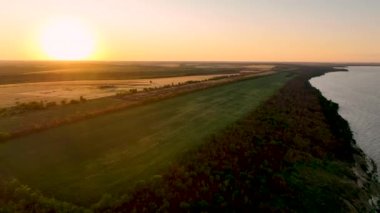 Bir yaz akşamında Kakhovka rezervuarının üzerinde günbatımının Arial videosu. Kherson bölgesi. Yüksek kalite 4k görüntü.