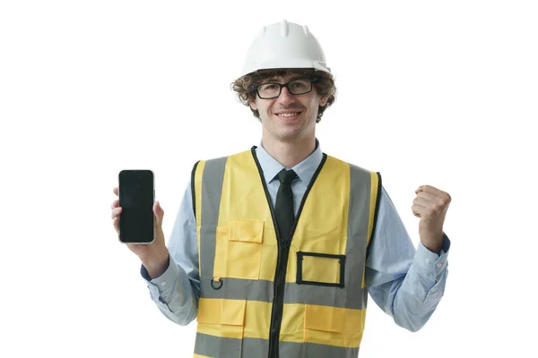 エンジニアの男性は笑顔で 刺激的な表情でスマートフォンを見せます 携帯電話で物事を示す概念 — ストック写真