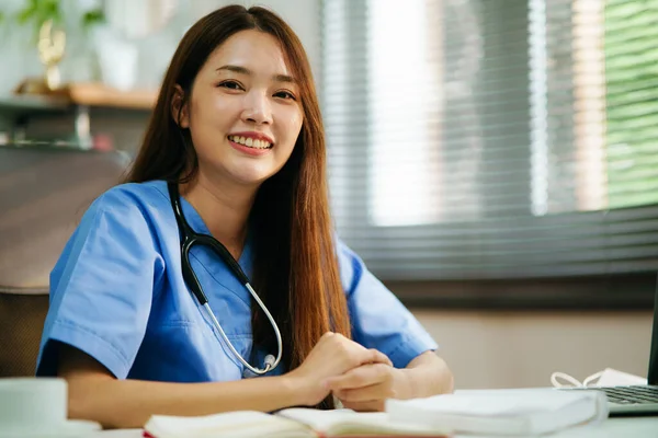 中等特写的亚洲女医生或护士的肖像 听诊器微笑着坐在房间里拍照 乐观的医务人员在值班 医疗幸福的写照 — 图库照片