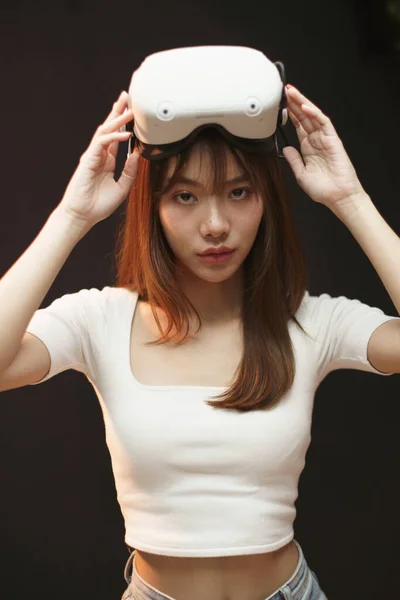 portrait of a woman put the VR headset on her head and looking at camera.