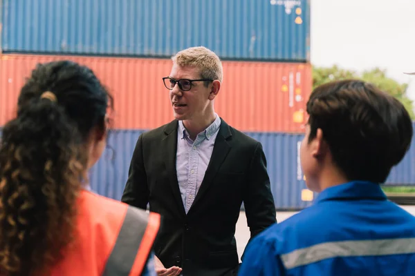 Shipping worker team update information together at the container yard as the background. shipment business teamwork. Professional team management and meeting.