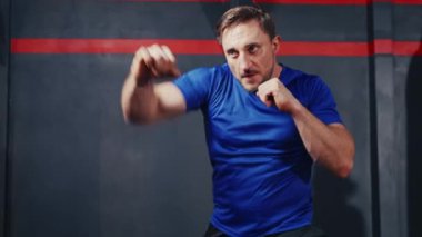 Close up shot of man keep practicing boxing in the gym. Athlete men doing air punching in sport club.