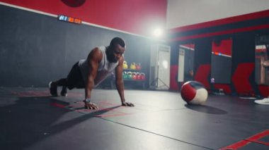 Spor salonunda şınav çeken siyahi bir adam..