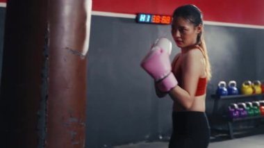 Spor salonunda Asyalı kadın boks antrenmanını yakından çek. Öfkeli kız kum torbasıyla boks yapar. Spor Dayanıklılık.