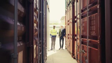 Foreman ve müfettiş, limanda lojistik ihracat ve ithalat kalite kontrolü için konteyner kutusunu inceliyor..