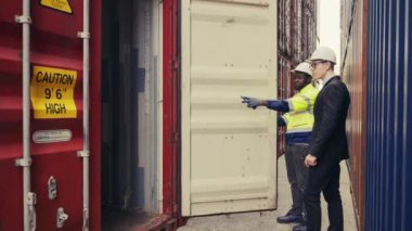 Foreman ve müfettiş, limanda lojistik ihracat ve ithalat kalite kontrolü için konteyner kutusunu kontrol ediyorlar..