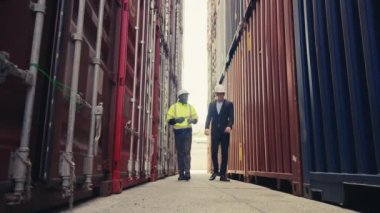 Foreman ve müfettişin düşük seviye açısı, limanda lojistik ihracat ve ithalatın kalite kontrolü için konteyner kutusunu kontrol ediyor..