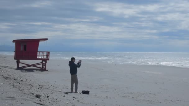 Travel Blogger Shoots Panorama Empty Beach Lifeguard Tower Background Lonely — Video