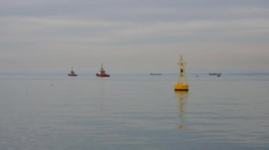 Static shot yellow buoy in port, on backstadge a tug boats. High quality 4k footage