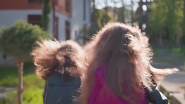 Back View Two School Girls Backpacks Run Street Houses Fluttering — Vídeos de Stock