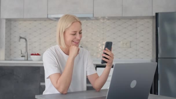 Молодая Улыбающаяся Радостная Блондинка Машет Рукой Прощание Заканчивает Видеоконференцию Смартфоне — стоковое видео