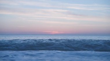 Medium sea waves roar and crash on shore at twilight time in beautiful pink sky, slow motion. High quality 4k footage
