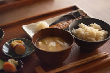 Healthy traditional Japanese breakfast in the 'ichiju-sansai' that has three dishes (one soup and three dishes) served on the table.