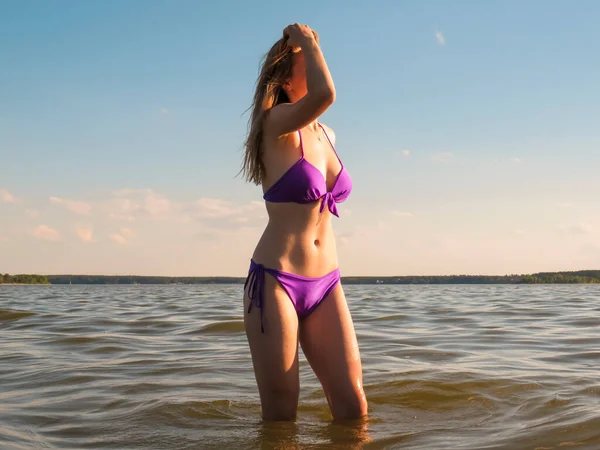 Egy Fiatal Vonzó Bikiniben Fürdőruhában Nap Narancssárga Fényében Víz Hátterében — Stock Fotó