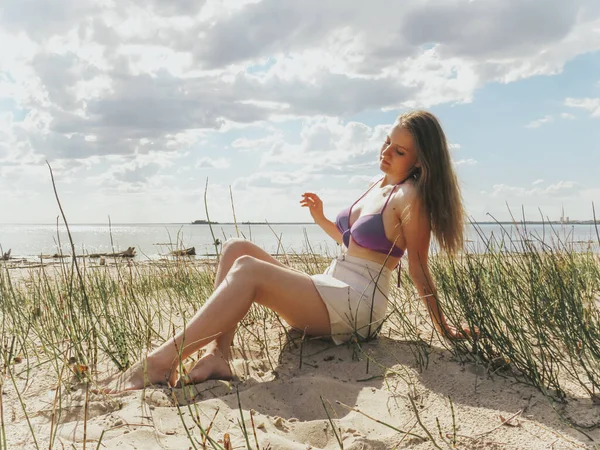 穿着比基尼的性感金发女人正在沙滩上晒日光浴 享受海滩娱乐和晒日光浴的理念 拥有美丽的女性身体 拥有健康的生活方式 在大自然中悠闲自在 — 图库照片