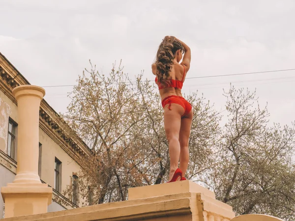 赤いレースの下着を着たセクシーなダークヘアの女性ダンサーは コンクリートの柱 美しさ 優雅さと女性の体の可塑性 エキゾチックなダンスでストリッピングを実行します — ストック写真