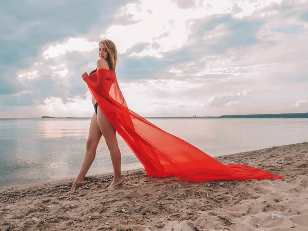 Siyah Bikinili Genç Bir Kadın Kumlu Bir Sahilde Kırmızı Bir — Stok fotoğraf