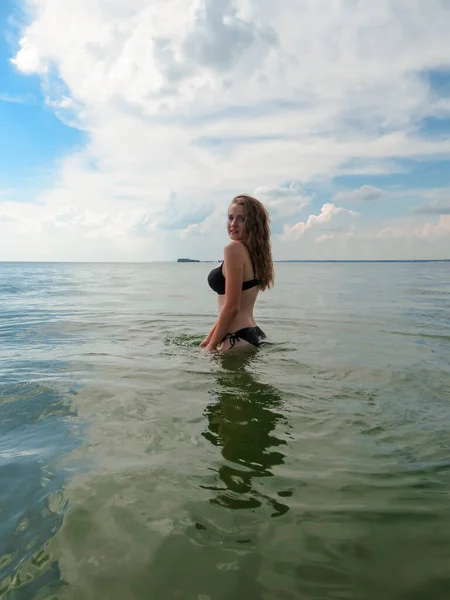 비키니를 아름다운 여성은 여름날푸른 구름을 배경으로 바다에서 수영을 해변의 일광욕 — 스톡 사진