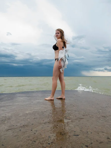 비키니를 수영복을 셔츠를 바람에 나부끼는 금발의 머리를 어두운 폭풍우를 배경으로 — 스톡 사진