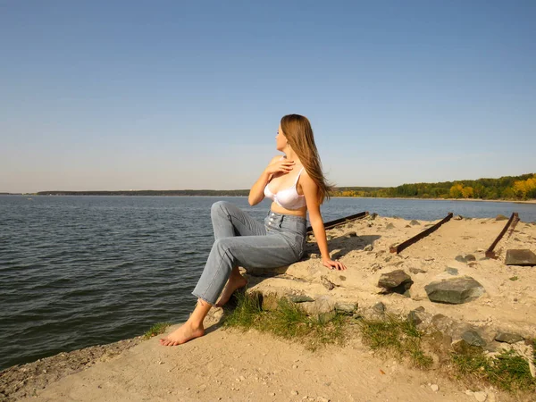 Uma Jovem Mulher Descalça Loira Sutiã Branco Jeans Azuis Gosta — Fotografia de Stock