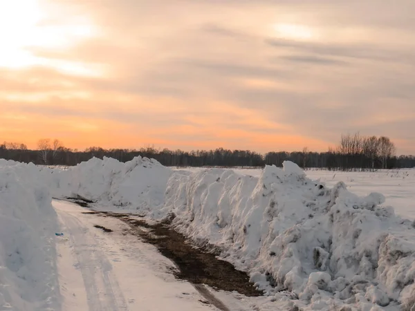 夕日の田園地帯 シベリアの冬の風景 冬の時間を通る雪のドリフトの冬の道 — ストック写真